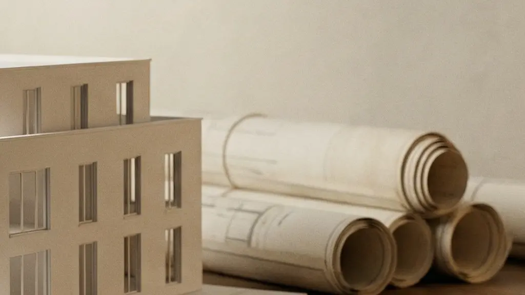Maquette architecturale d'un immeuble neuf posée sur une table avec des clés dorées et des plans de construction flous en arrière-plan, symbolisant l'achat sur plan en VEFA